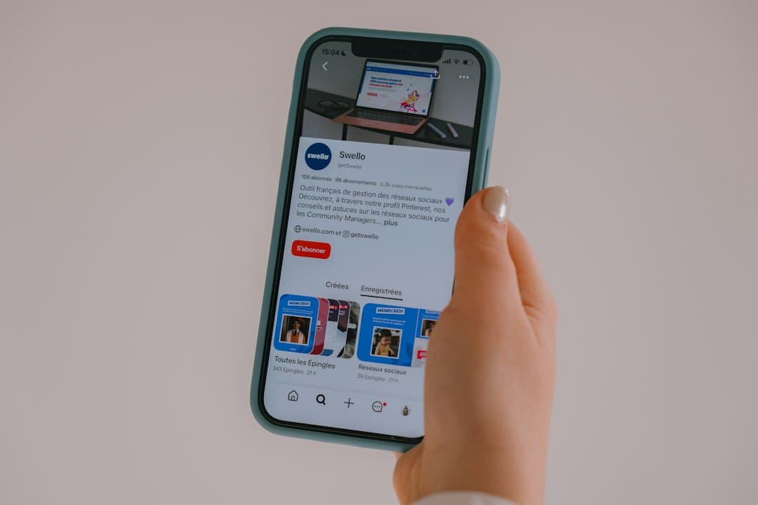 A hand holding a smartphone showing a social media feed