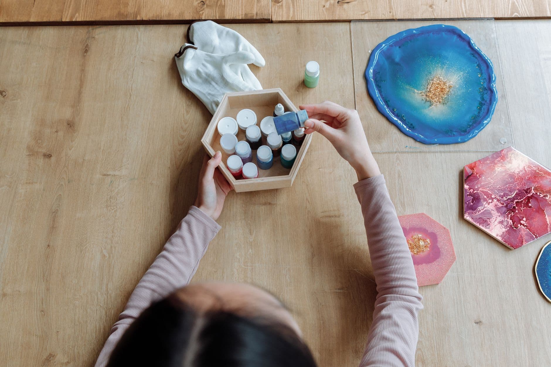 A woman creating colorful resin art at home