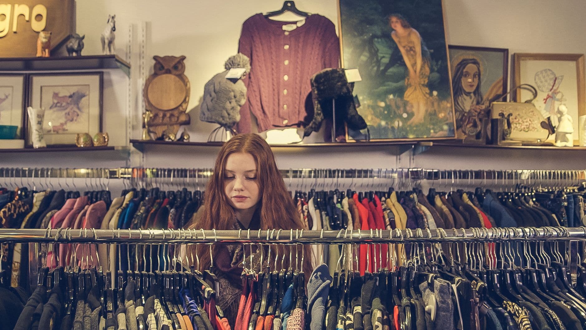A woman browsing clothing racks in a vintage shop