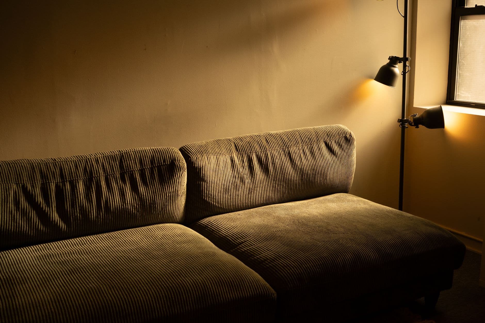 A corduroy sofa in a cozy, warmly lit room