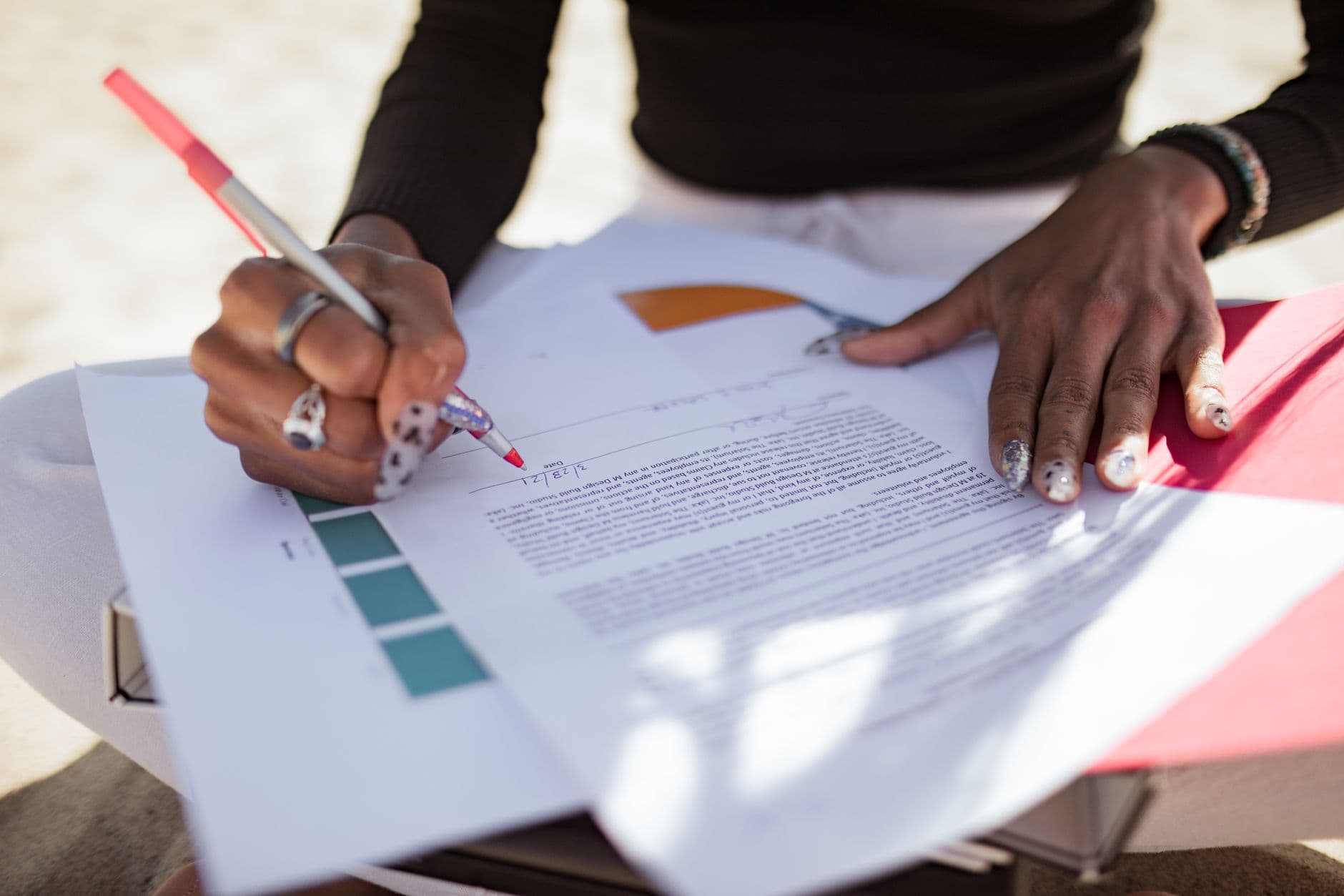 A person editing papers with a red pen