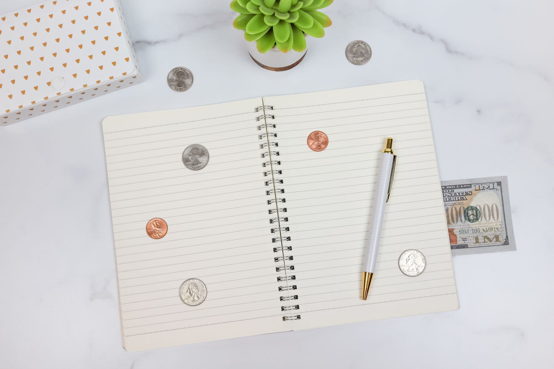A notebook, pen and money on a desk for financial planning