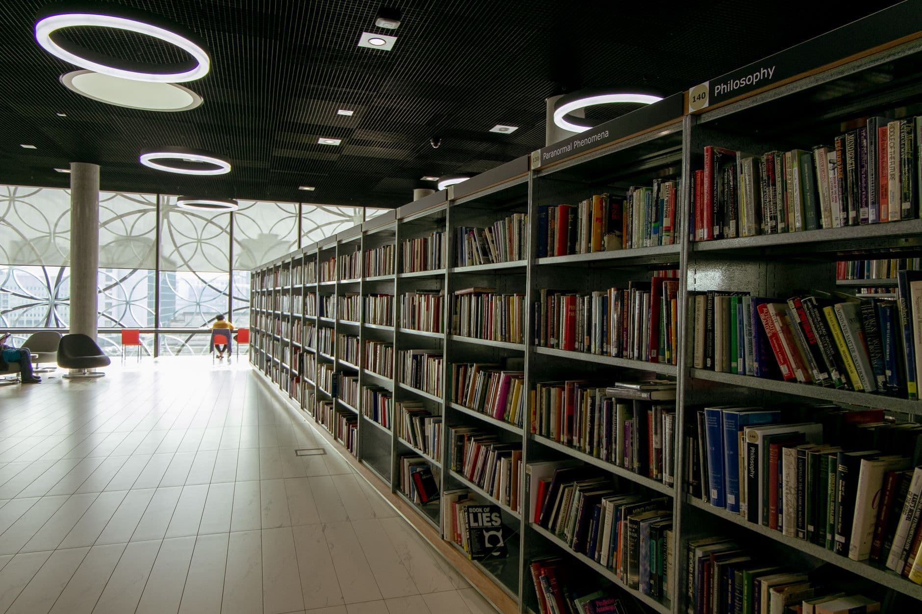 A quiet modern library with bookshelves and circular lights