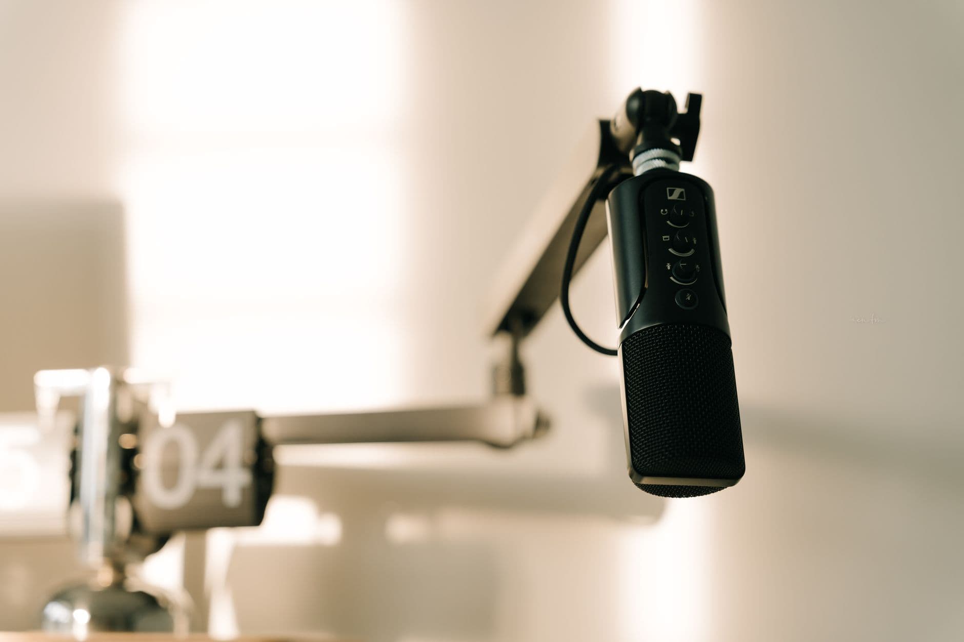 A professional microphone on a boom arm in a studio