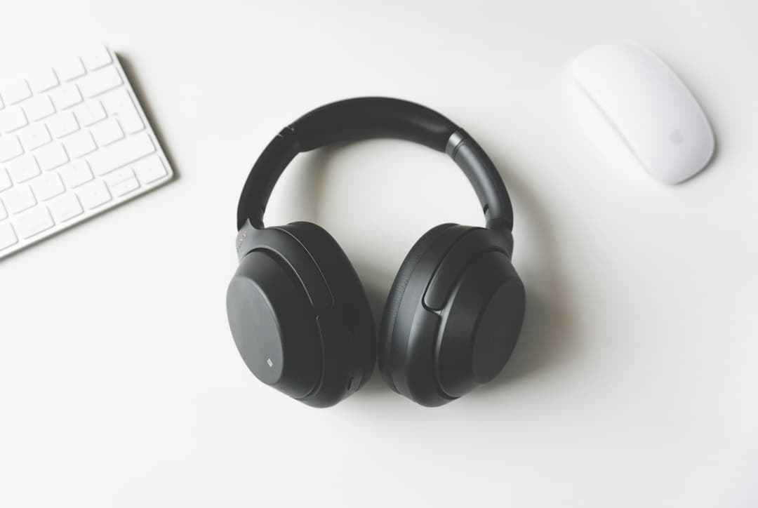 Wireless headphones between a keyboard and a mouse on a desk