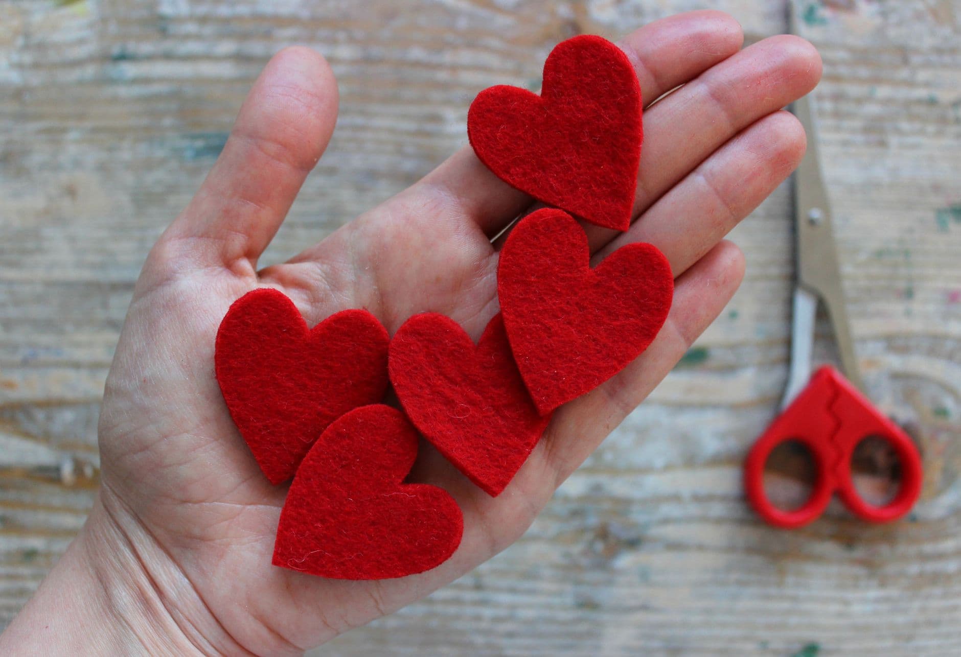 A hand holding red felt hearts for Valentine's crafts