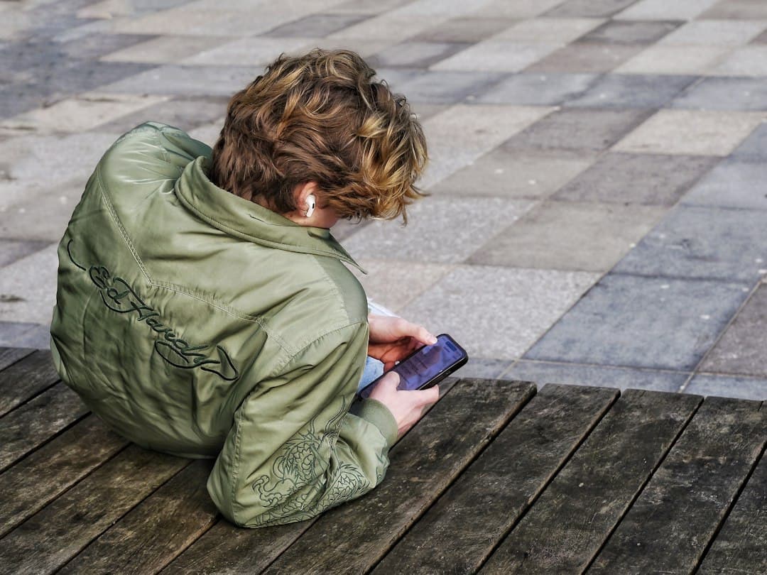 A young person with curly hair using a smartphone
