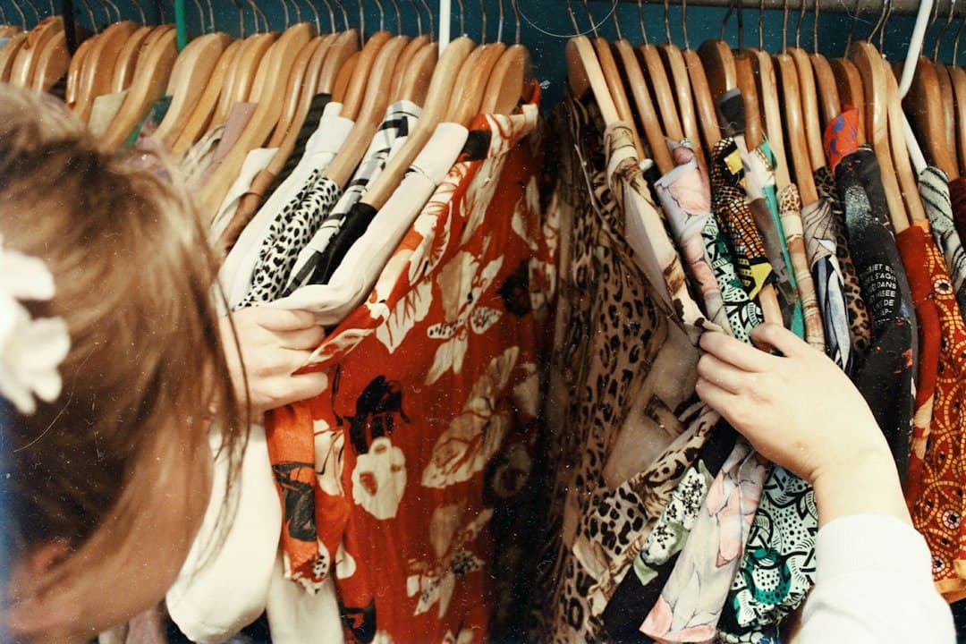 A person holding clothes on wooden hangers