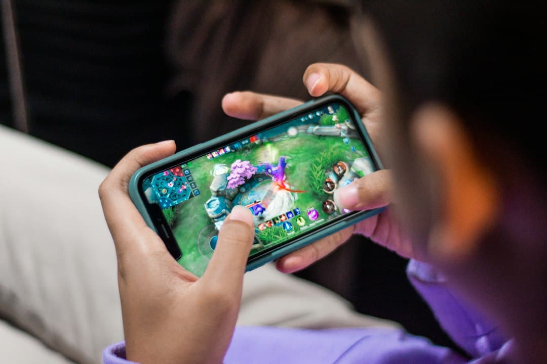 A person holding a smartphone and playing a mobile game