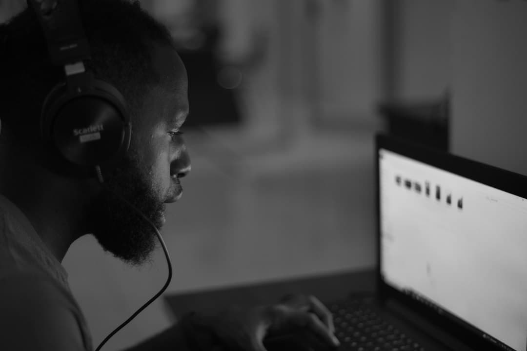A man wearing headphones while working on a laptop